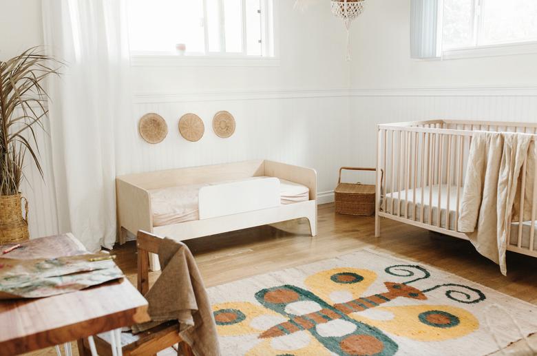 Minimal bohemian baby nursery idea with vintage butterfly rug