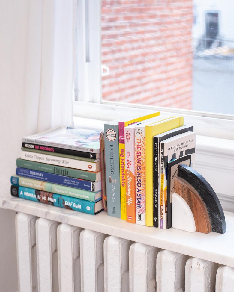 book storage ideas with a marble shelf on top of a radiator makes a small bookshelf.