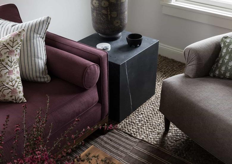 neutral carpet colors in living room with grasscloth flooring and purle couch