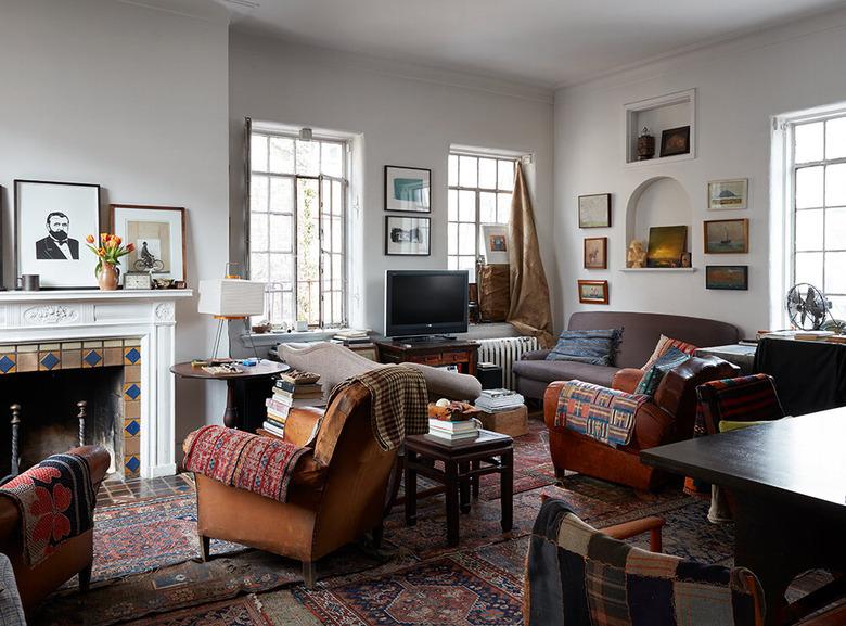 patterned carpet colors in living room with multiple rugs and leather arm chairs