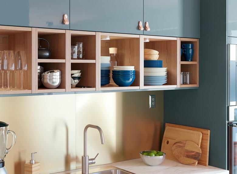 blue kitchen with open shelving and gold metal backsplash