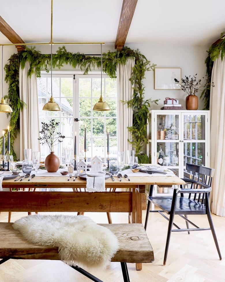 Christmas centerpiece in dining room with table and brass pendants