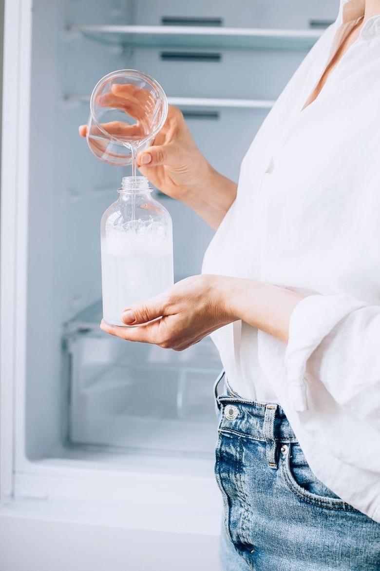 Cleaning bottle in front of refrigerator