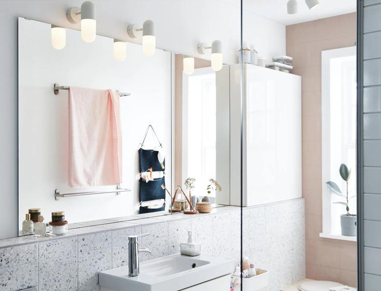 coastal bathroom lighting idea with wall sconces in pink and white space