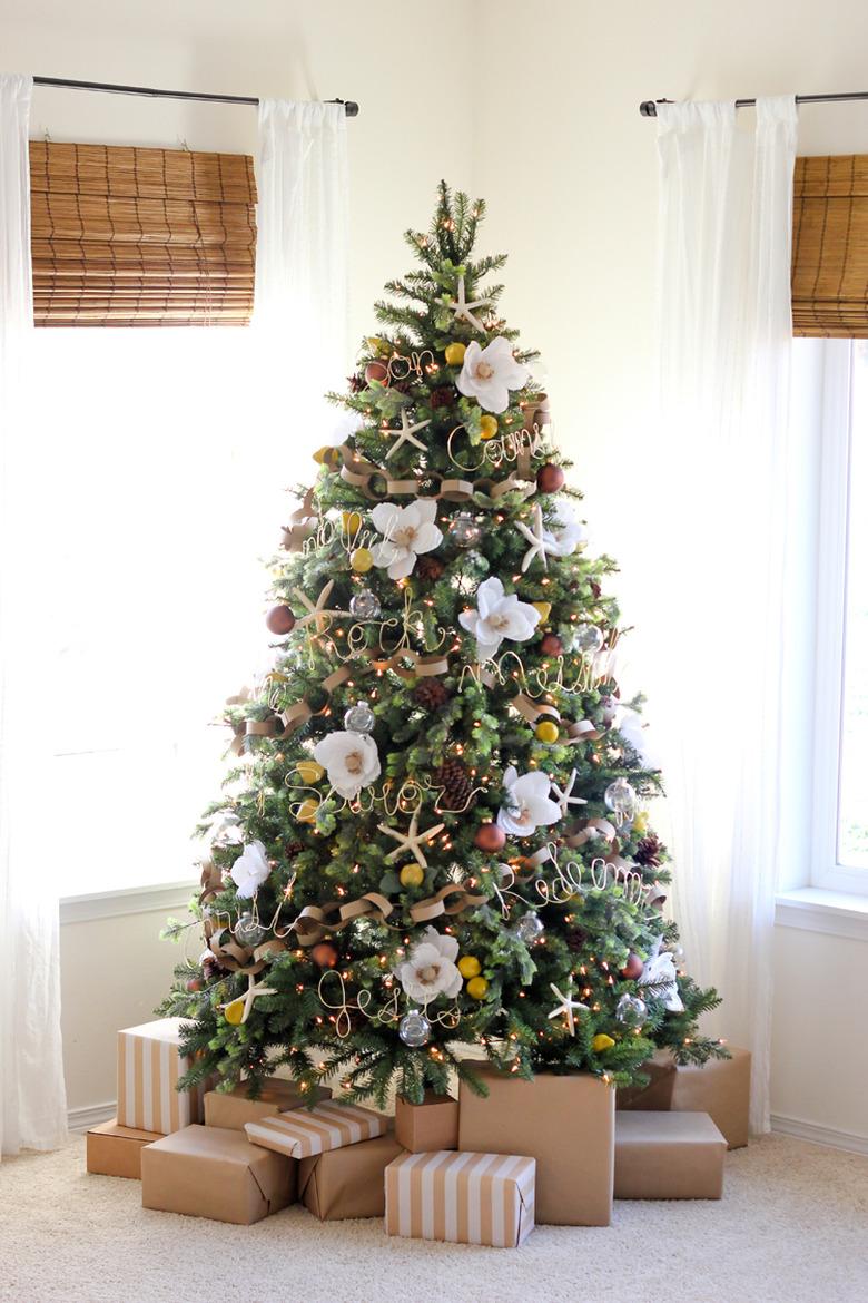 coastal Christmas tree with giant faux magnolia, glass bulbs, and gold wire