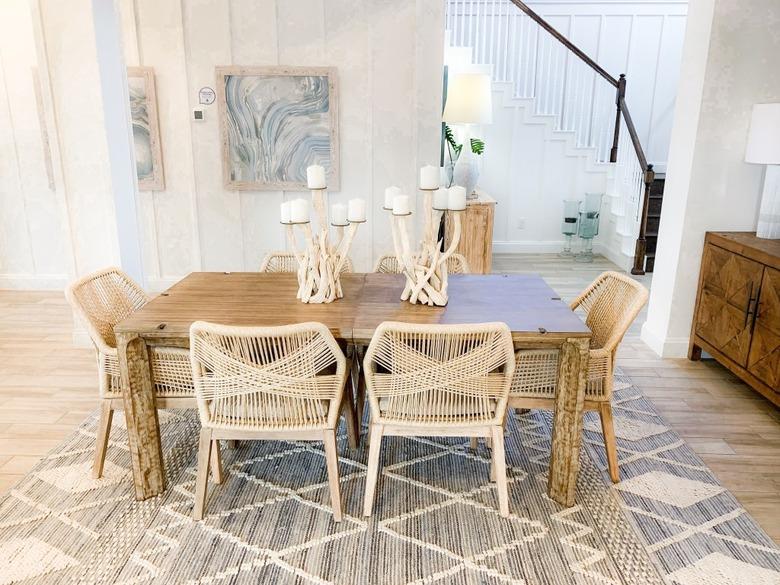 modern coastal dining room with woven chairs and driftwood candle holders