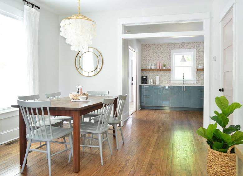 minimalist coastal dining room with capiz chandelier and blue windsor chairs