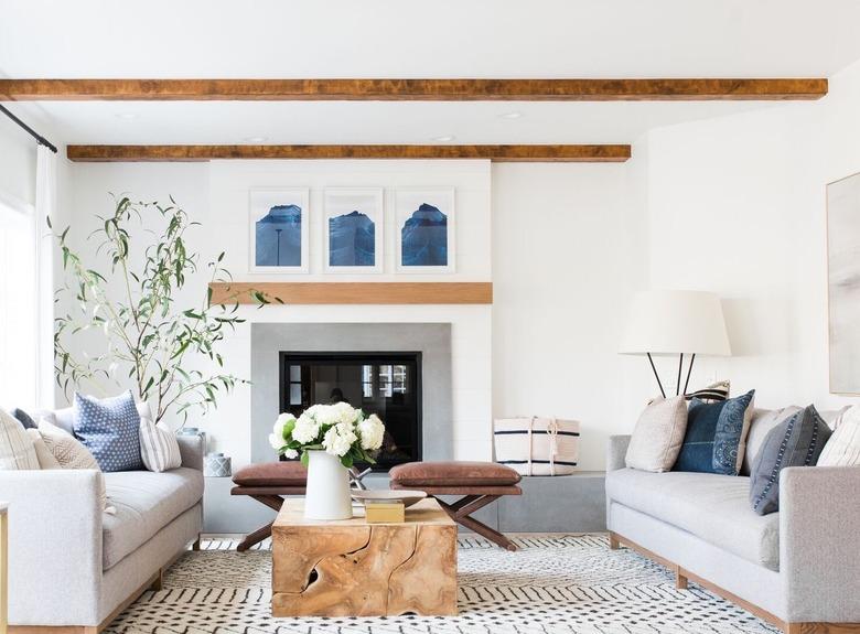 white living room with coastal fireplace and wooden beams