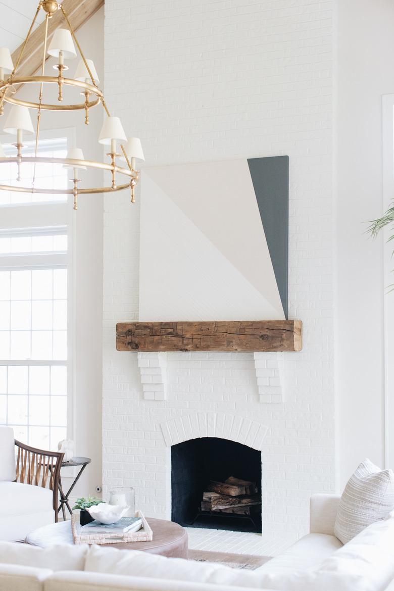 white living room with coastal fireplace and art above the mantel