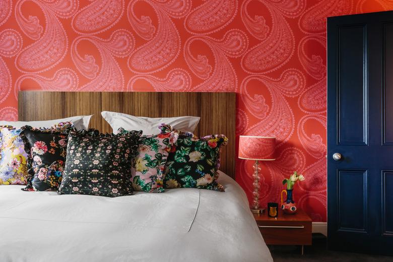 color meaning in sophisticated bedroom with red paisley wallpaper