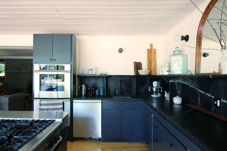 Minimalist kitchen with soapstone countertops and black cabinets