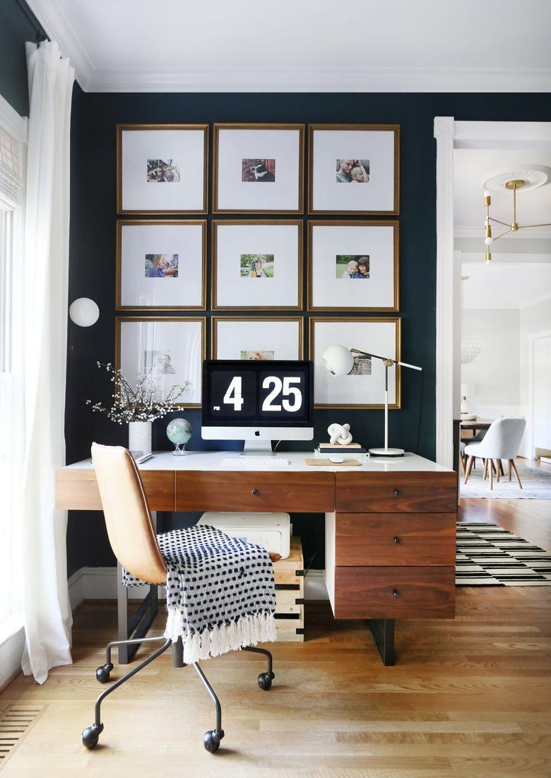 corner home office with gallery wall and wood desk