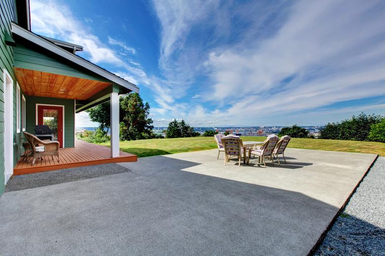 VIew of large concrete floor patio area at backyard