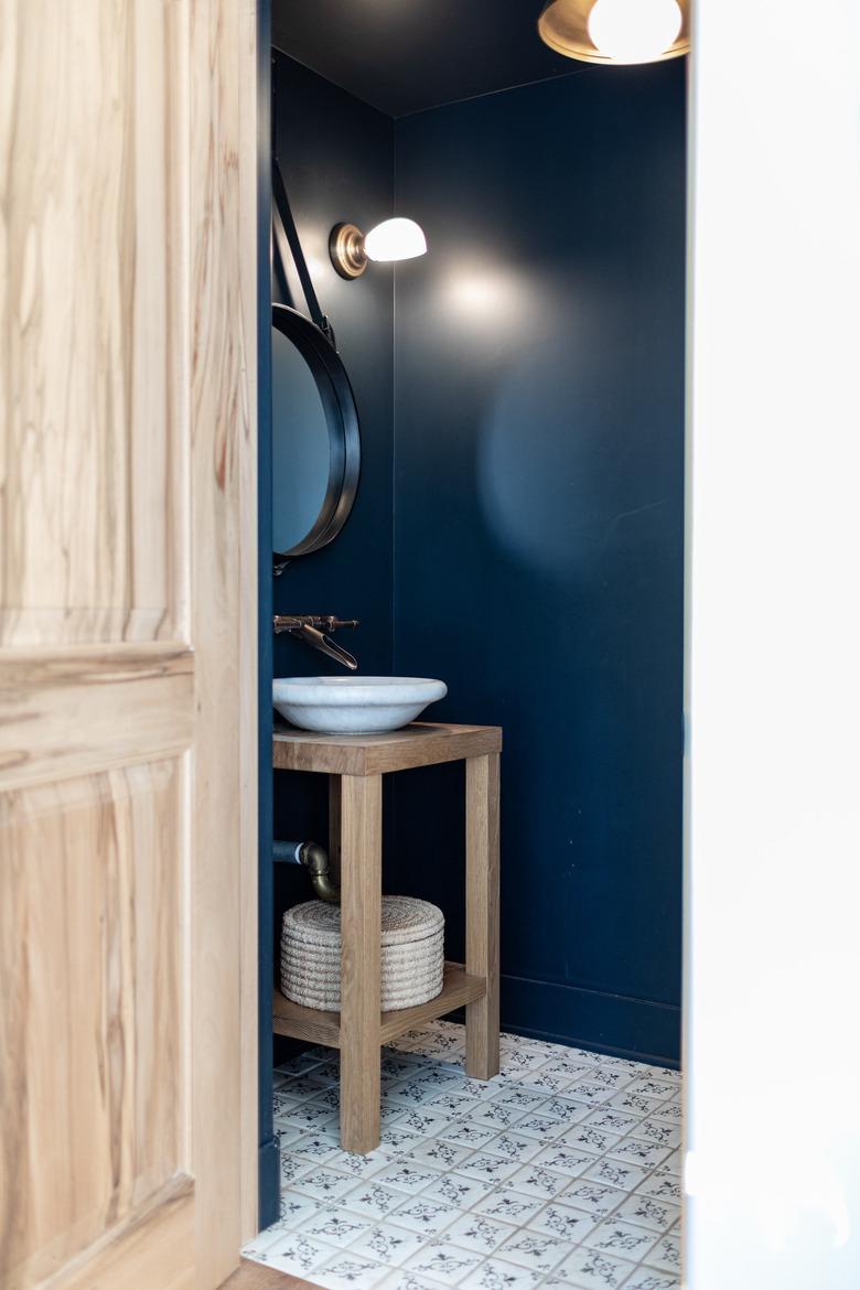 black powder room with wooden vanity