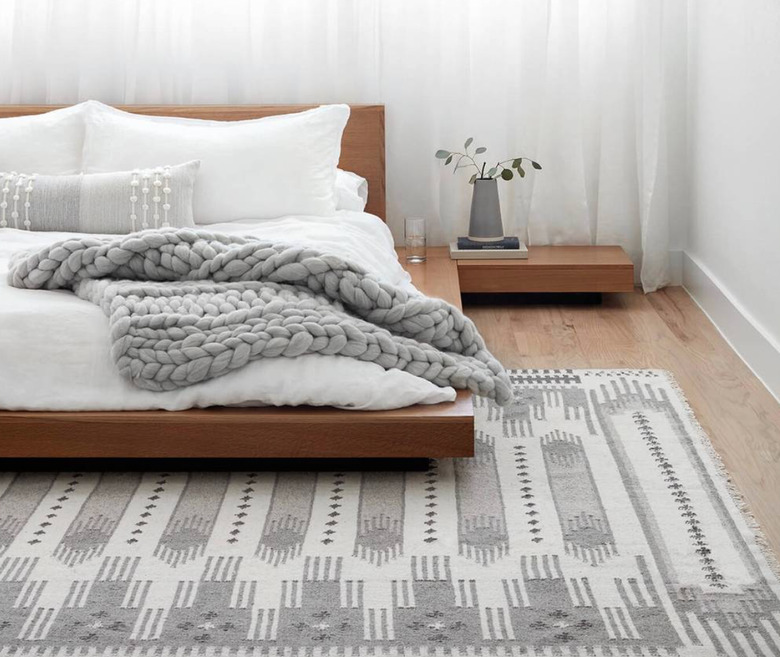 desert themed bedroom with simple wood platform bed and grey tones