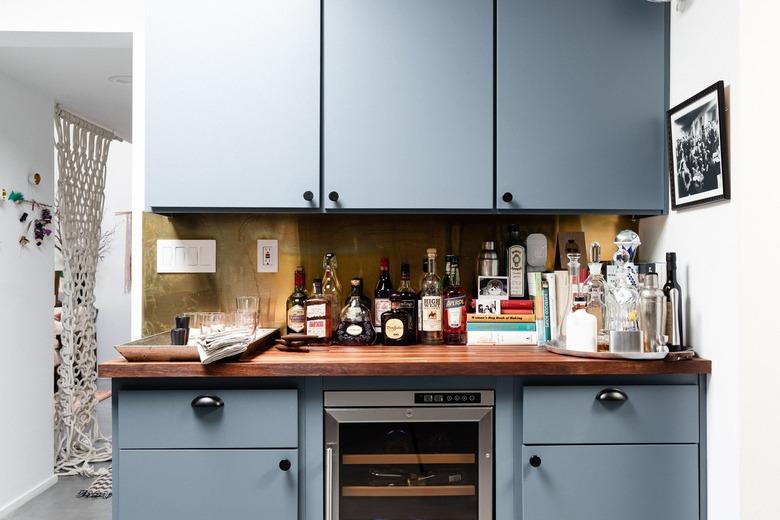 A blue painted home bar with a wine fridge