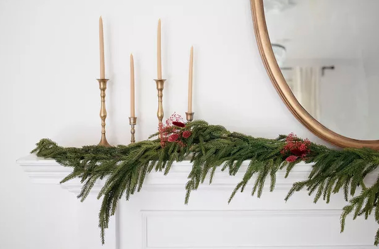 Dried floral garland on mantel with candles