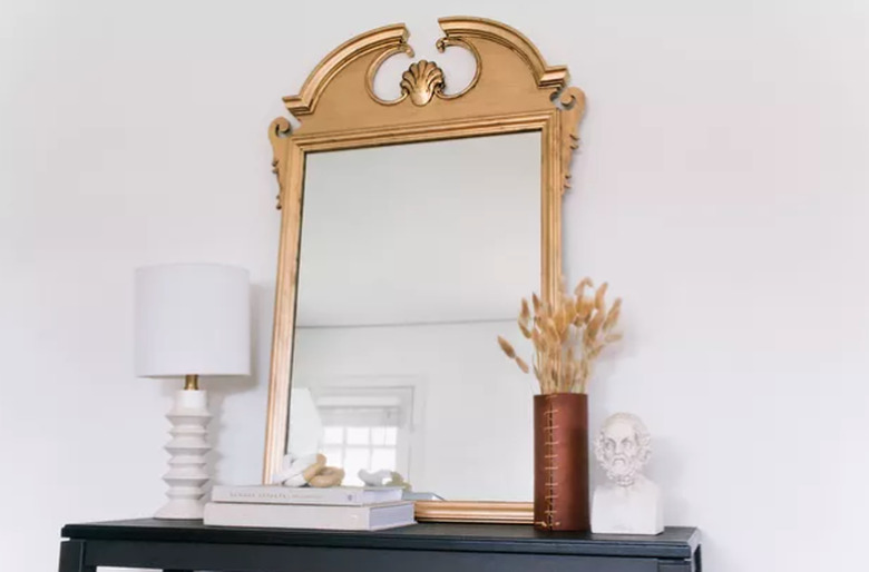 Gilded mirror on shelf