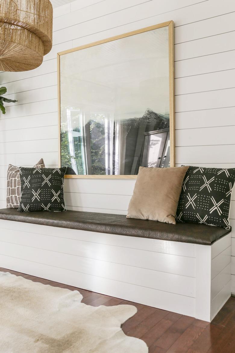 DIY storage bench with white shiplap and mud cloth pillows