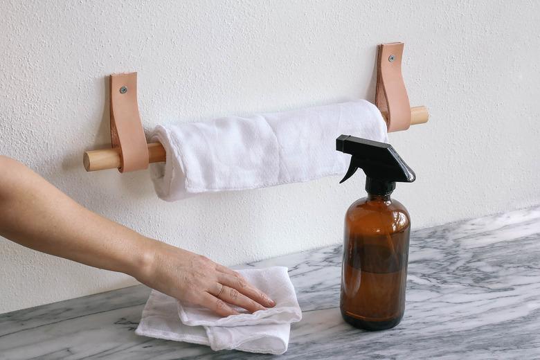 Fabric towels hung on leather and wood holder