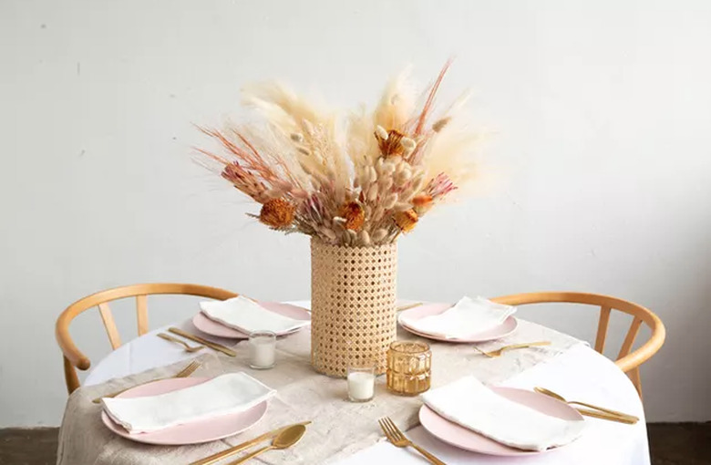 Cane-wrapped vase with dried plants and flowers