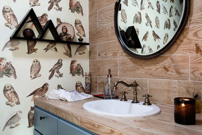 white oval drop in bathroom sink with antique brass fixture