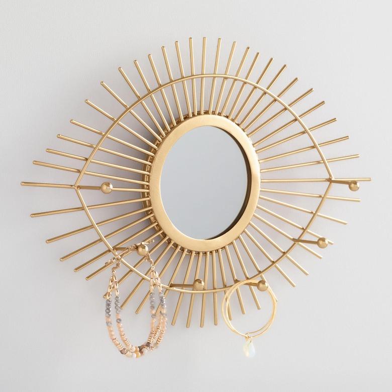 Earring Storage with Brass eye shaped mirror with jewelry hooks.