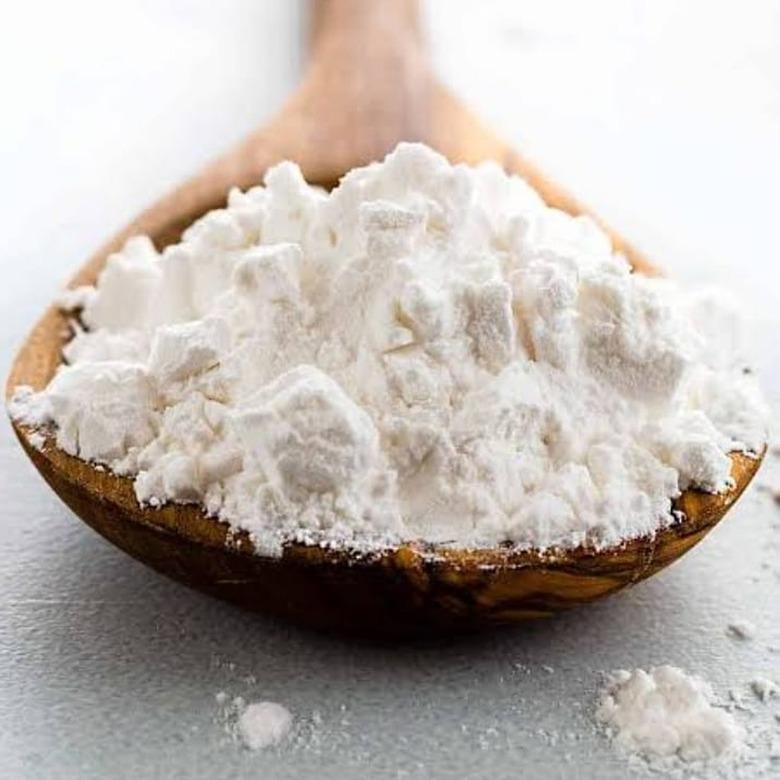 A wooden spoon full of arrowroot powder.