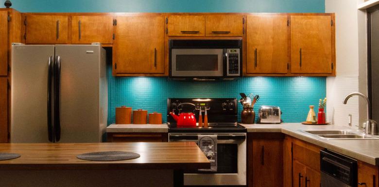 Retro wood cabinetry and teal backsplash