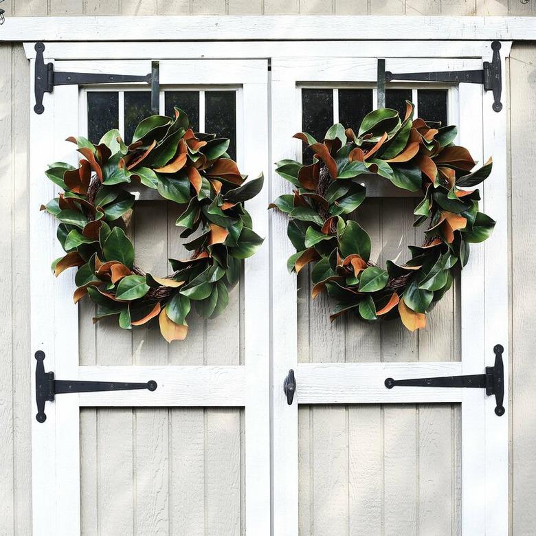 two magnolia leaf fall wreaths on barn doors