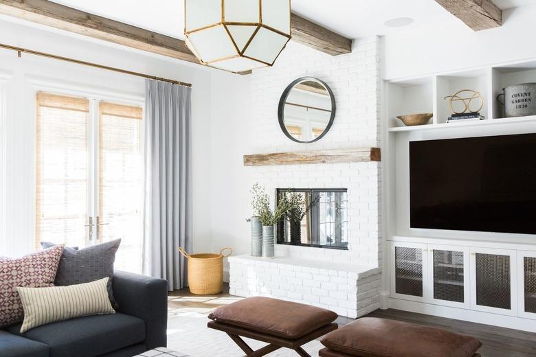 family room with fireplace and TV layout with exposed wood beams and leather ottomans