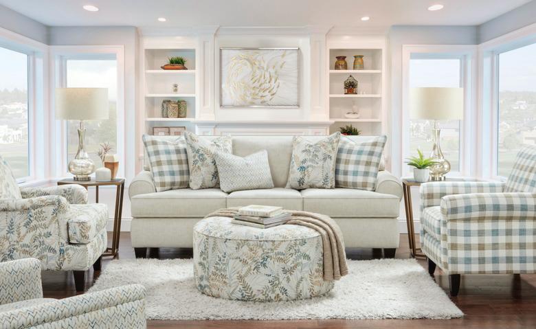 living room with couch, chairs, ottoman, lamps, rug in plaid and floral patterns