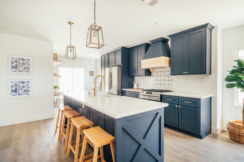 Blue and white modern farmhouse kitchen with brass and glass pendant lights