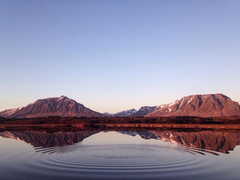 Mountains behind, water in front.