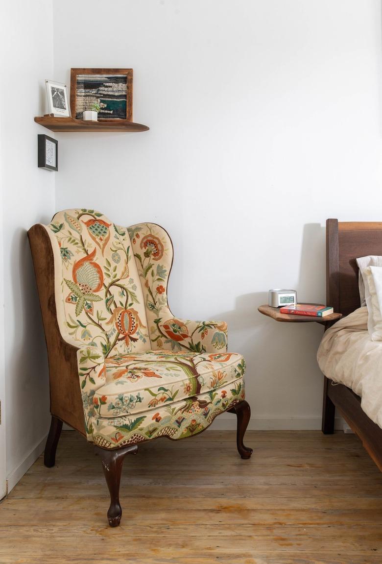 Antique wingback chair in corner of bedroom