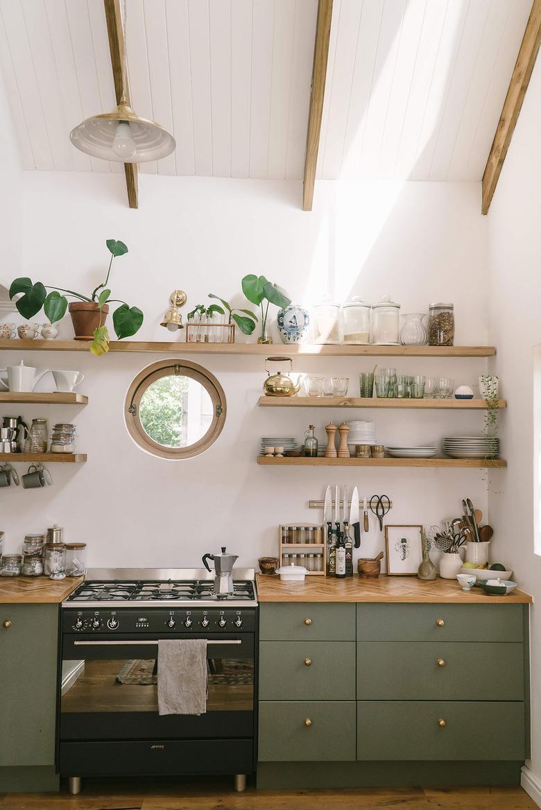 white and sage green kitchen with gas stovetop