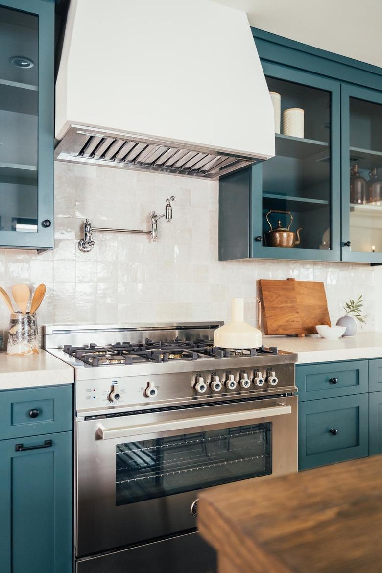 stainless steel gas stovetop with blue cabinets