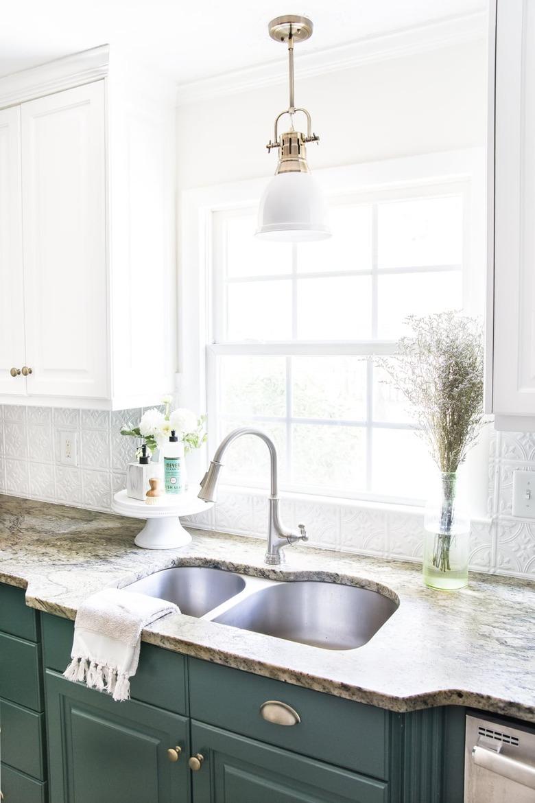 Budget kitchen lighting above sink with green lower cabinets and white upper cabinets