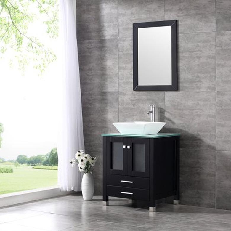 glass bathroom countertop with white vessel sink near window