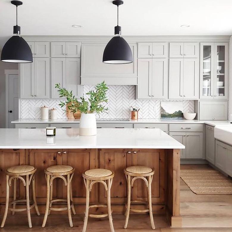 gray kitchen color idea with wood island and herringbone tile backsplash