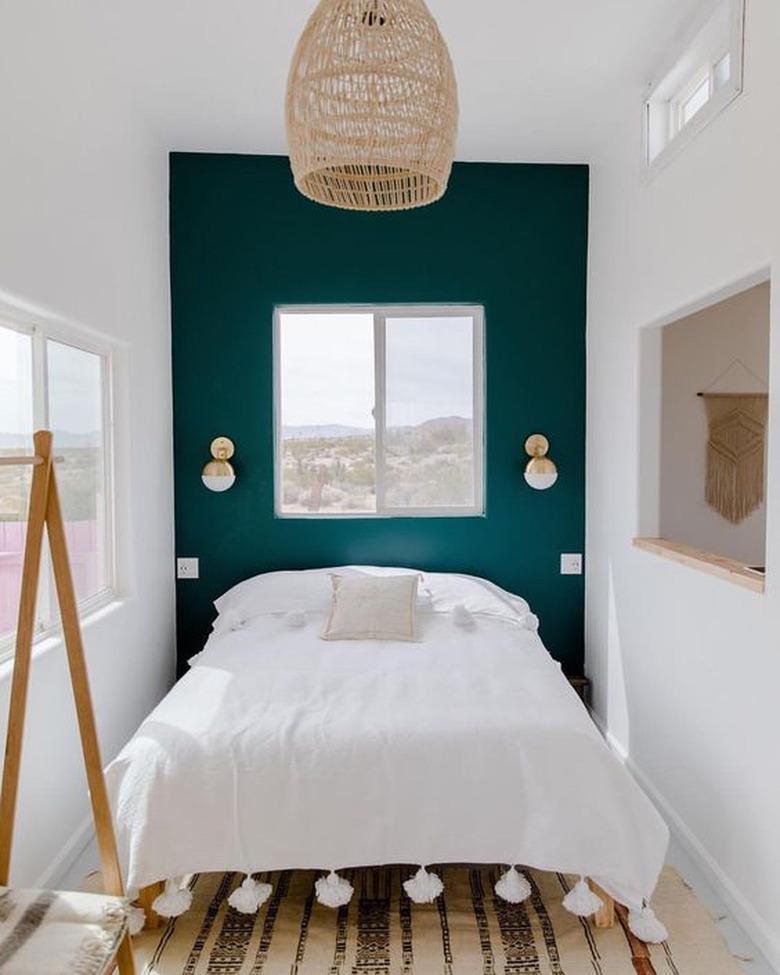 green boho room with woven pendant and tasseled duvet