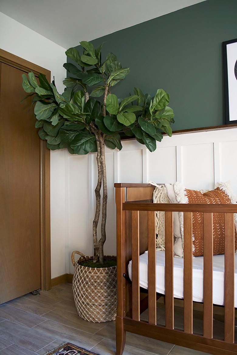 Green boho room with faux fiddle leaf fig tree and crib