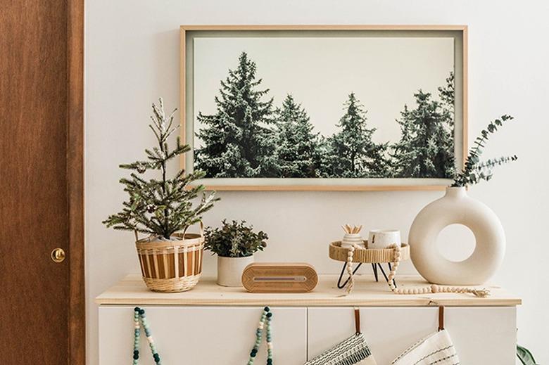 Pine tree wall art with circular white vase and modern decor touches