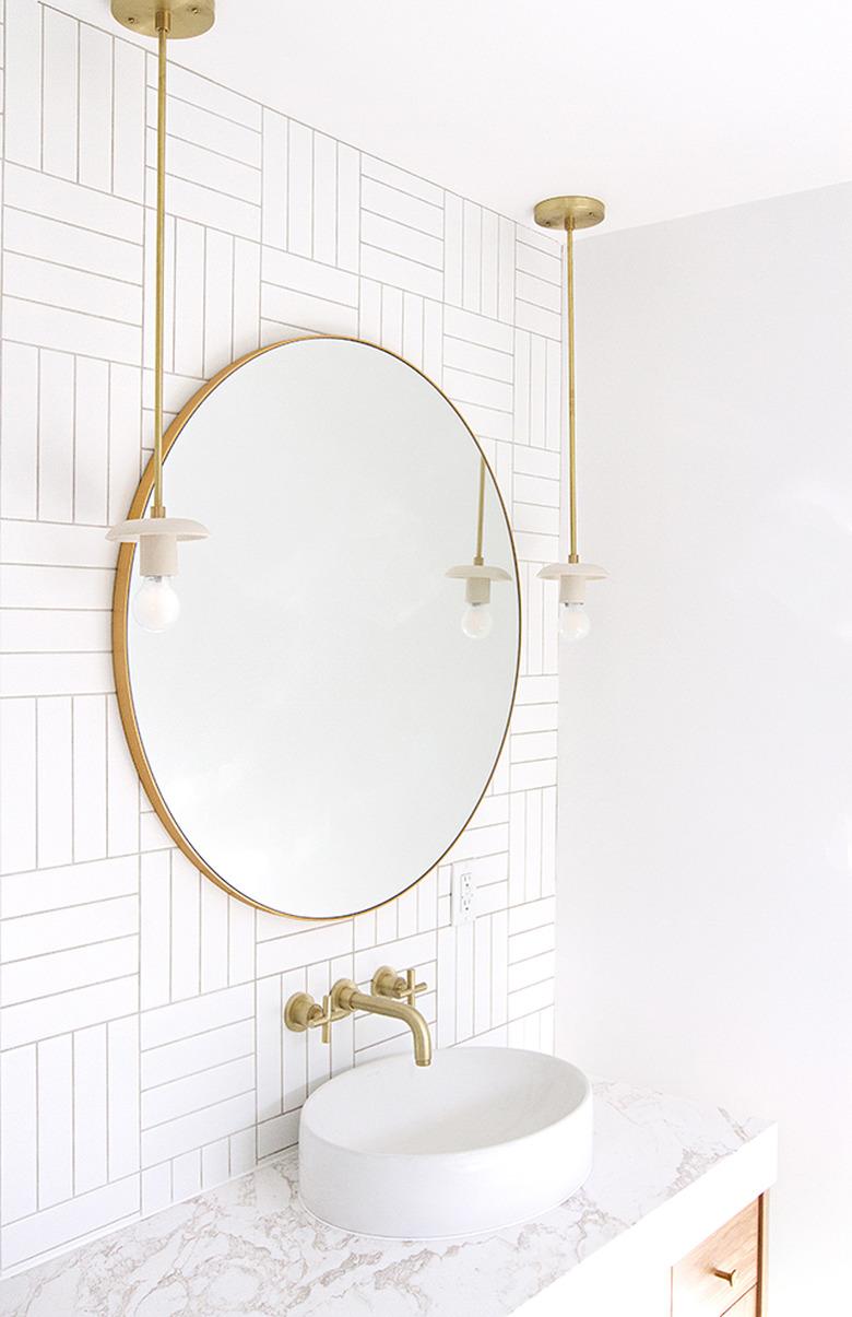 white half bathroom idea with brass fixtures and round vessel sink