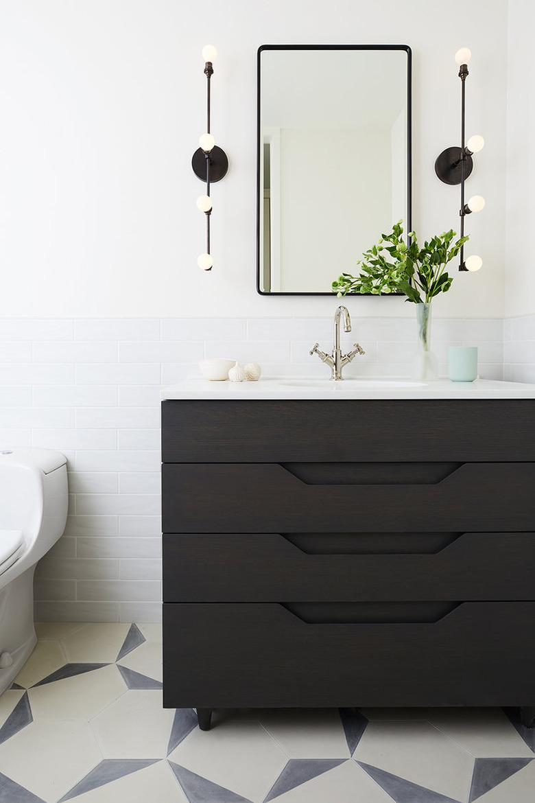 white half bathroom idea with black vanity cabinet and patterned floor tile