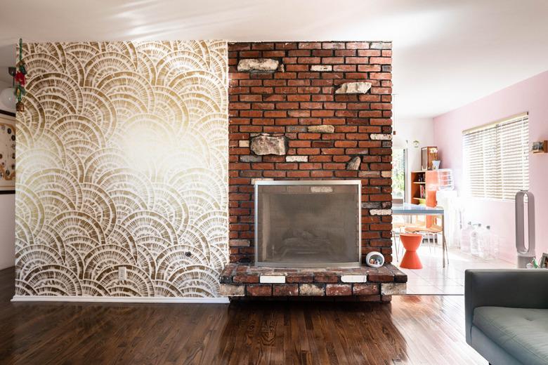 red-toned brown hardwood floor colors in living room with brick wall and wallpaper