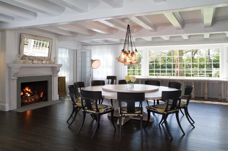 dark brown hardwood floor colors in dining room with fireplace and white ceiling beams