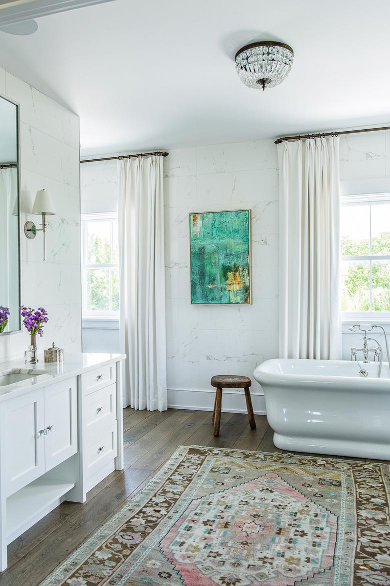 flush mount bathroom light fixture on ceiling with freestanding bathtub and white vanity cabinet