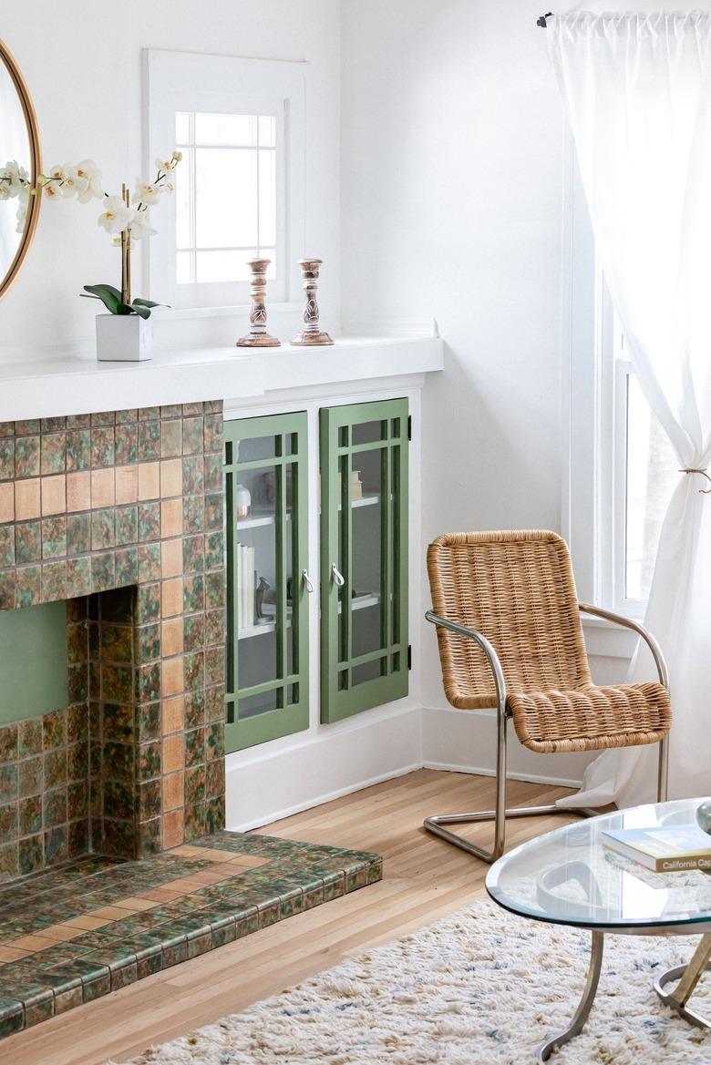 A white-walled living room with green and neutral accents and wood floors