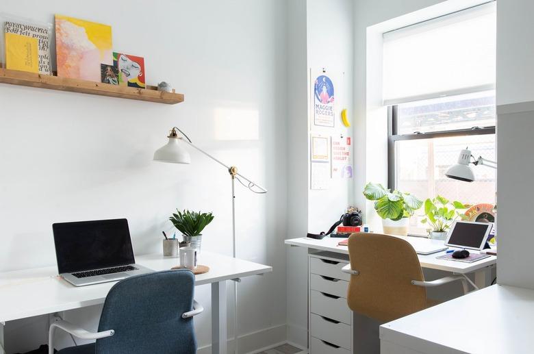 Home office with two desks and chairs with wood shelf